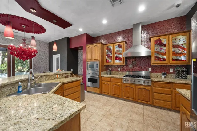 a kitchen with stainless steel appliances granite countertop wooden cabinets and a refrigerator