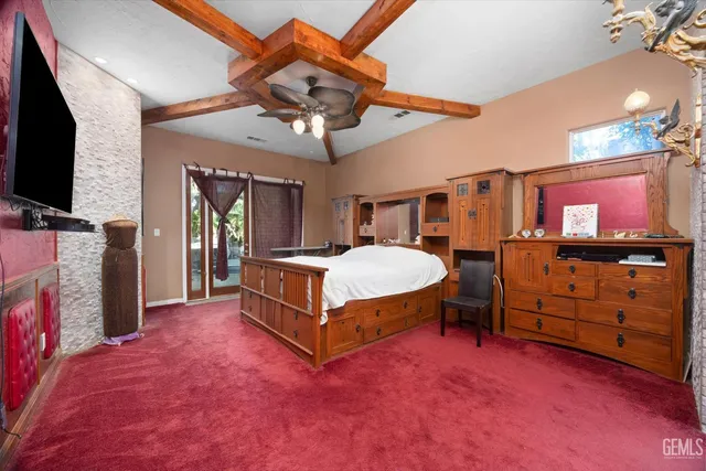 a spacious bedroom with a bed and a flat tv screen on dresser