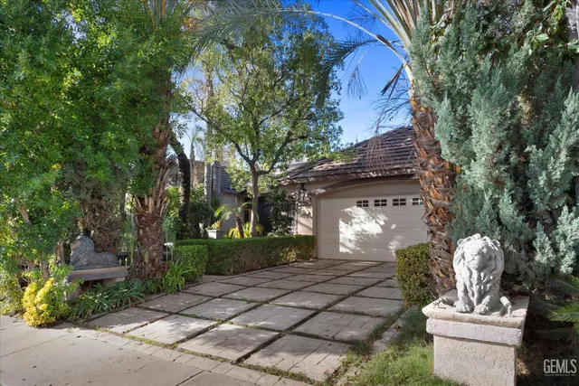 a front view of a house with a yard and tree s