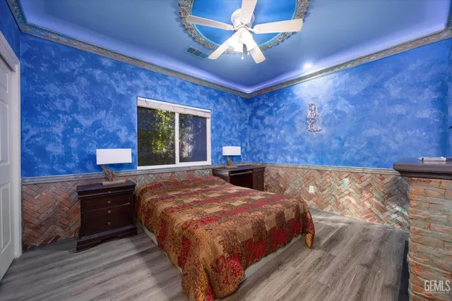 a spacious bedroom with a bed and a flat screen tv