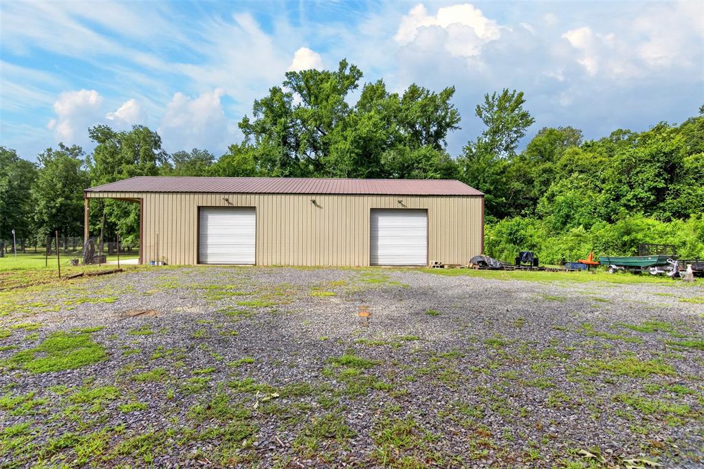 11868 Timber Ridge Drive Keithville, LA 71047 - Photo 36 of 37 Metal outbuilding featuring two bay doors and an extended covered awning