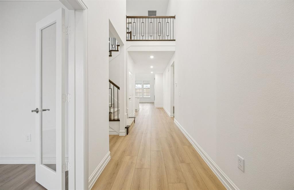 11216 Abbotsbury Road Fort Worth, TX 76052 - Photo 3 of 20 a view of a hallway with wooden floor and staircase