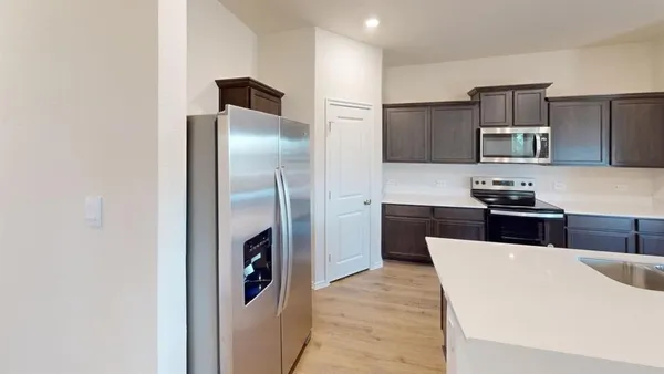 a kitchen with stainless steel appliances granite countertop a refrigerator and a stove top oven