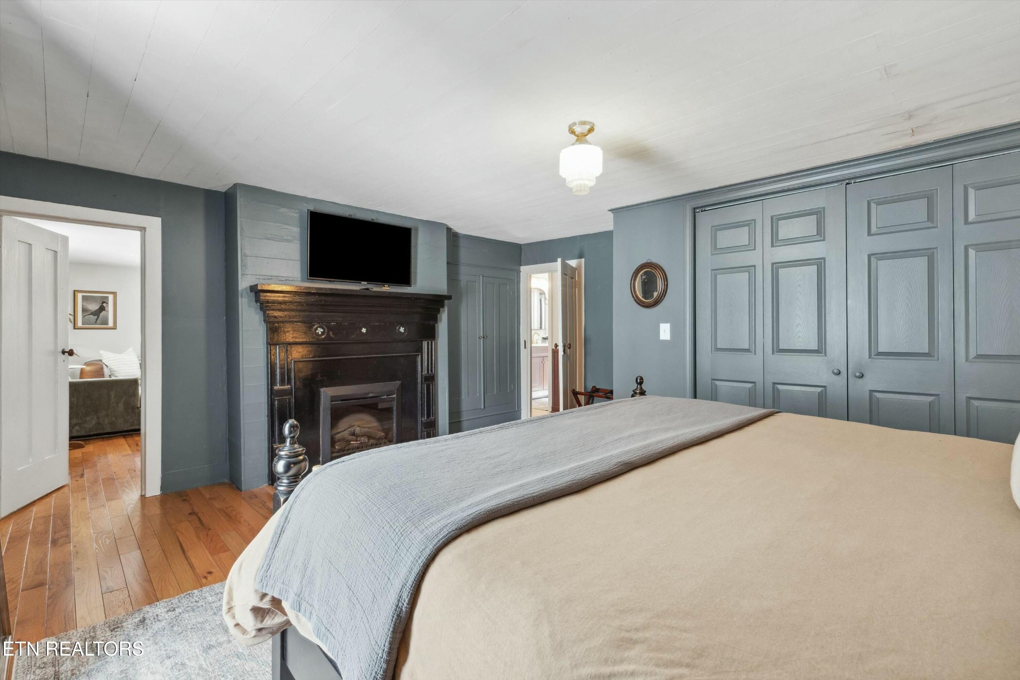 1216 Powder Springs Road Sevierville, TN 37876 - Photo 19 of 45 a spacious bedroom with a bed and a flat screen tv