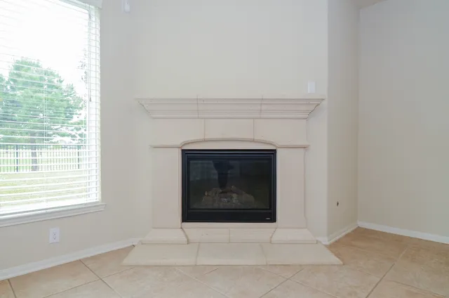 an empty room with a fireplace and fan