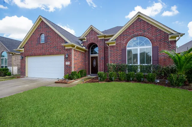 a front view of a house with a yard and garage