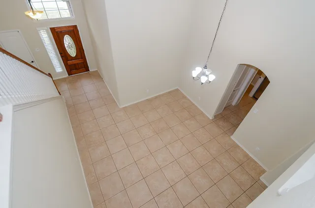 wooden floor with chandelier and glass door