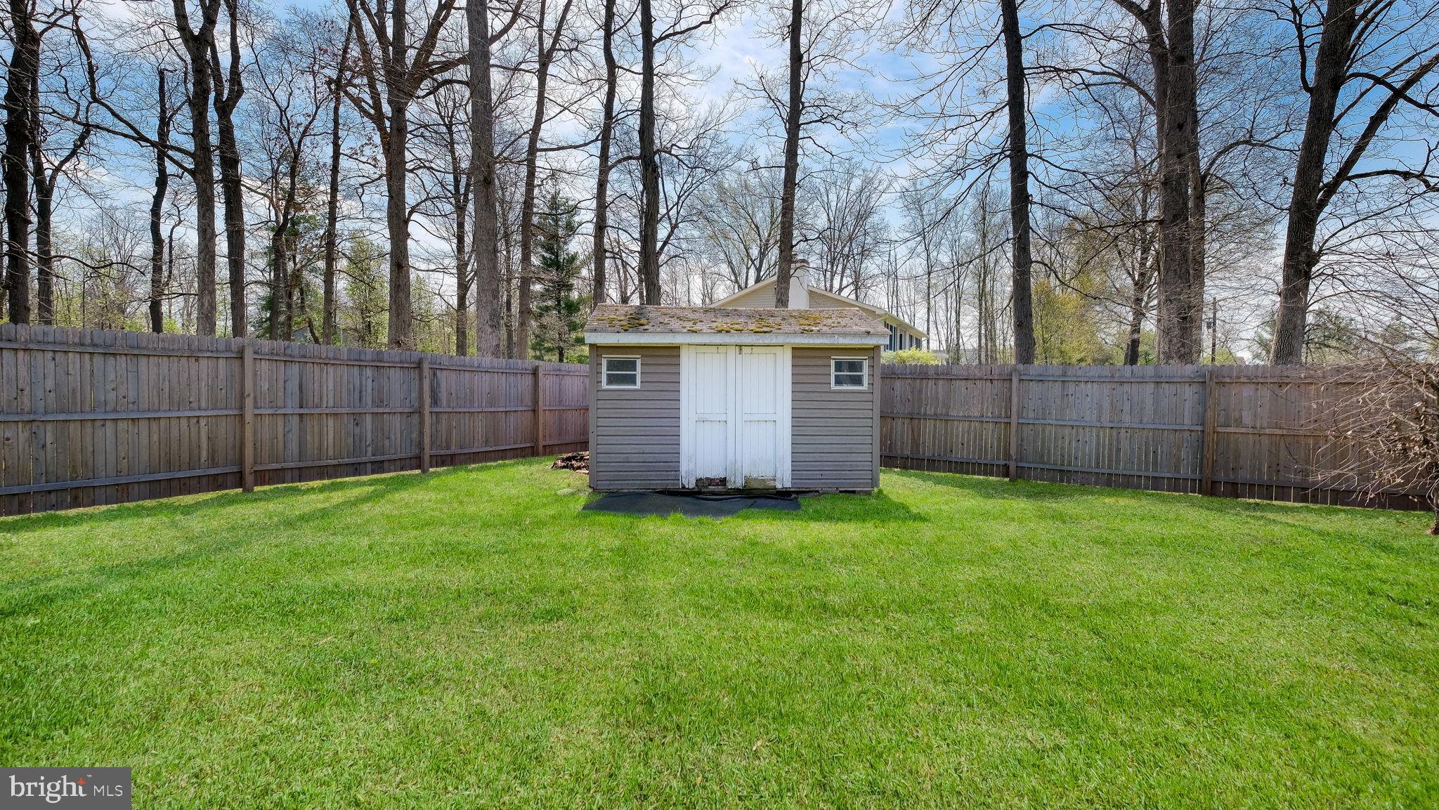 152 Blooming Glen Road Perkasie, PA 18944 - Photo 32 of 37 a view of a backyard with large trees and wooden fence