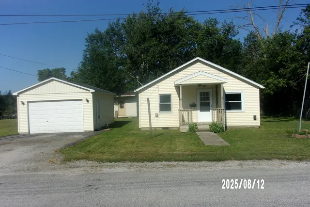 a front view of a house with a garden and yard