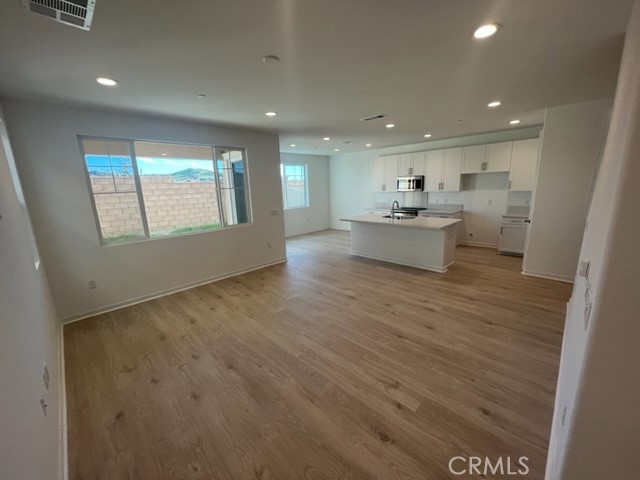 31373 Trappers Loop Winchester, CA 92596 - Photo 2 of 15 an open kitchen with a sink and dishwasher with wooden floor