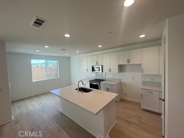 31373 Trappers Loop Winchester, CA 92596 - Photo 3 of 15 a kitchen with a refrigerator a sink and wooden floor