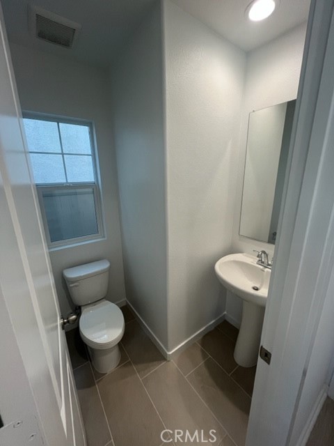 31373 Trappers Loop Winchester, CA 92596 - Photo 7 of 15 a bathroom with a toilet a sink and a mirror