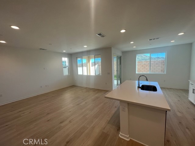 31373 Trappers Loop Winchester, CA 92596 - Photo 8 of 15 a kitchen with kitchen island a sink dishwasher and a stove with wooden floor