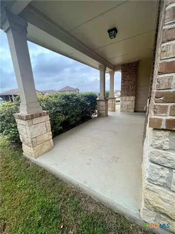 a view of a patio with table and chairs potted plants with floor to ceiling window
