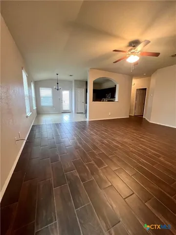 a view of a livingroom with an empty space and a kitchen