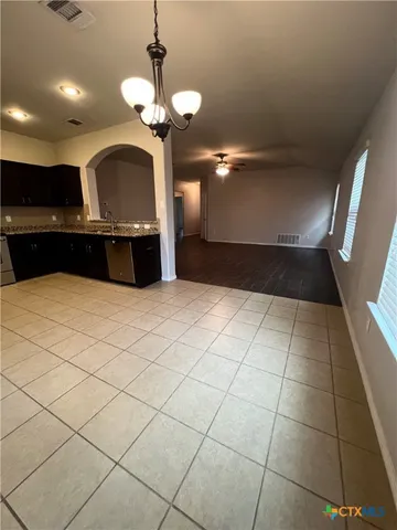 a kitchen with kitchen island granite countertop a sink a counter space and cabinets