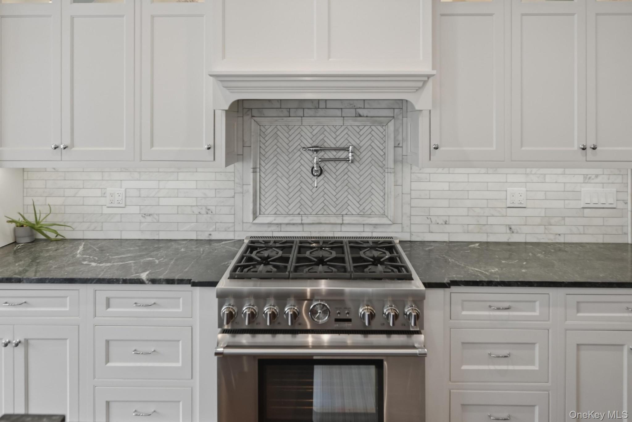 42 Skunks Misery Road Locust Valley, NY 11560 - Photo 14 of 50 Gourmet kitchen featuring a stainless steel Thermador range with a pot filler, white shaker cabinetry, and dark countertops