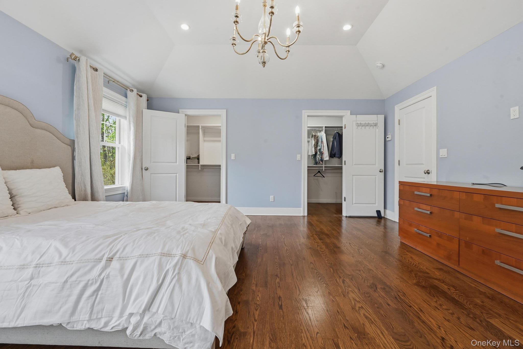 42 Skunks Misery Road Locust Valley, NY 11560 - Photo 26 of 50 Spacious room featuring vaulted ceilings, a decorative chandelier, recessed lighting, lustrous wood-finish flooring, and multiple walk-in closets
