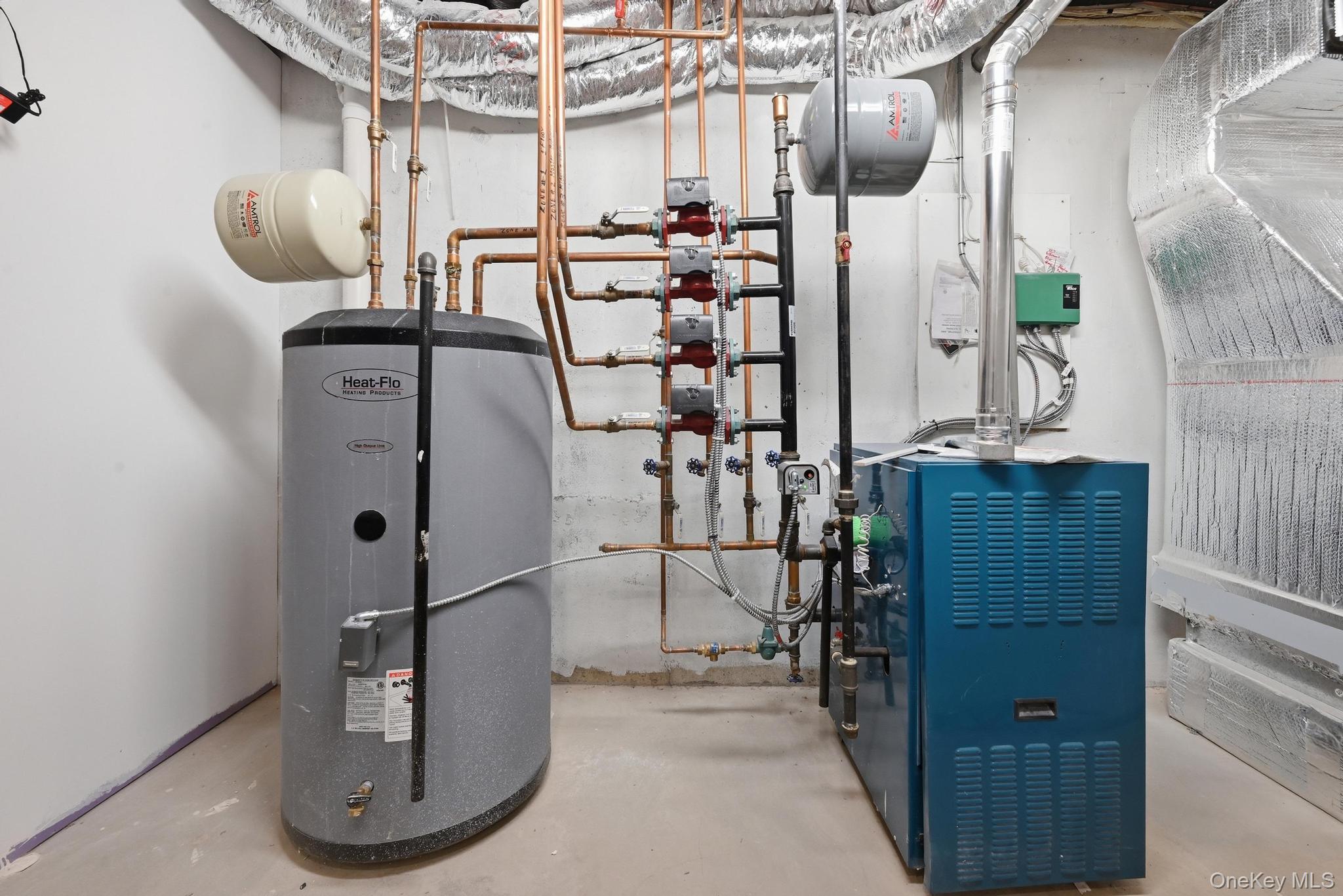 42 Skunks Misery Road Locust Valley, NY 11560 - Photo 39 of 50 Mechanical room featuring a gray water heater, a blue boiler, copper piping, and large silver ductwork