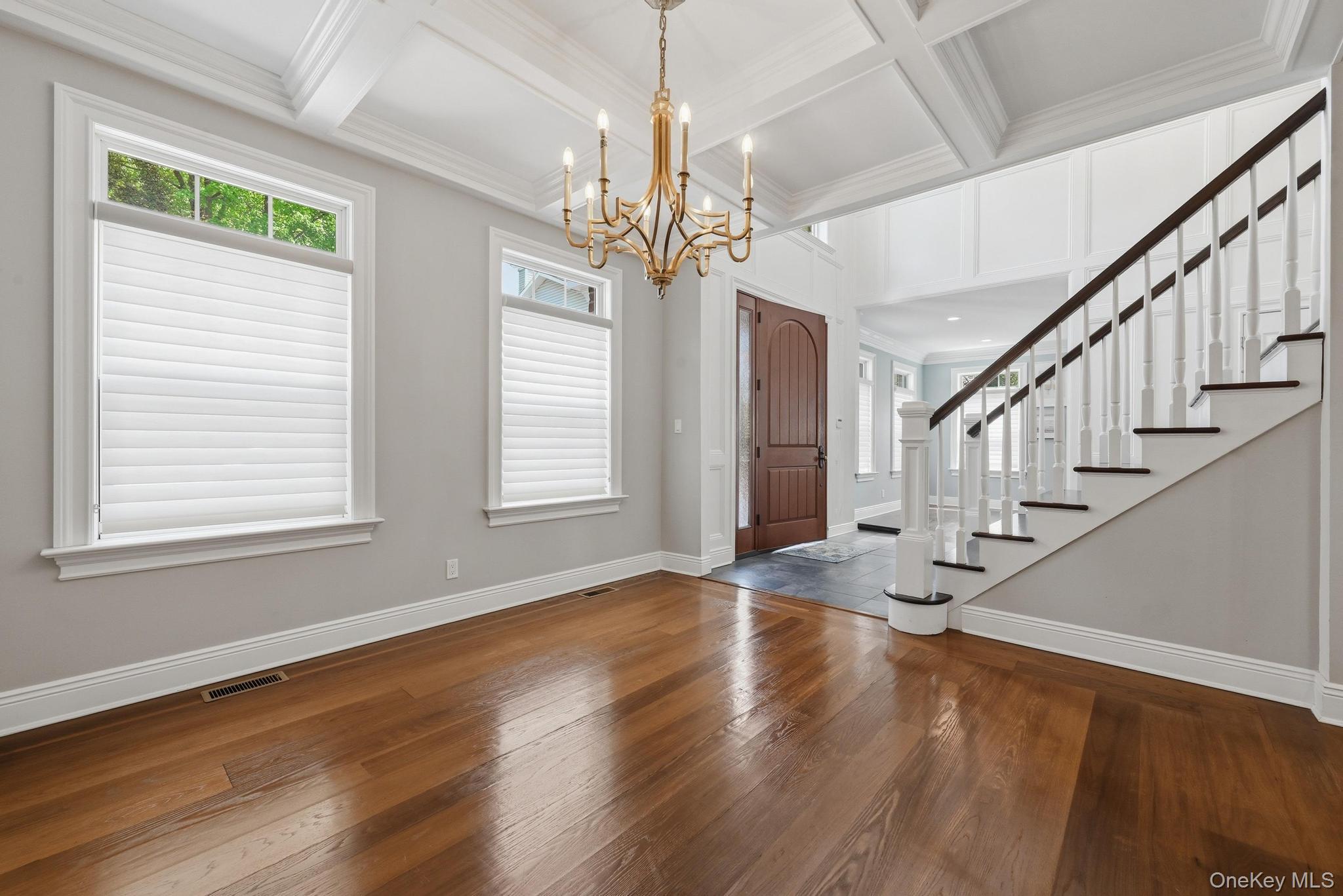 42 Skunks Misery Road Locust Valley, NY 11560 - Photo 6 of 50 Open foyer featuring a grand staircase with dark wood treads and white risers, coffered ceilings, and polished wood-finish flooring
