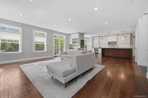 a large white kitchen with wooden floor and a sink