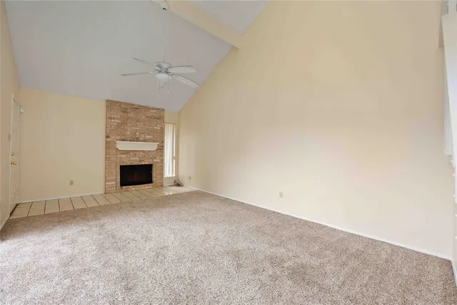 an empty room with a fireplace and fan