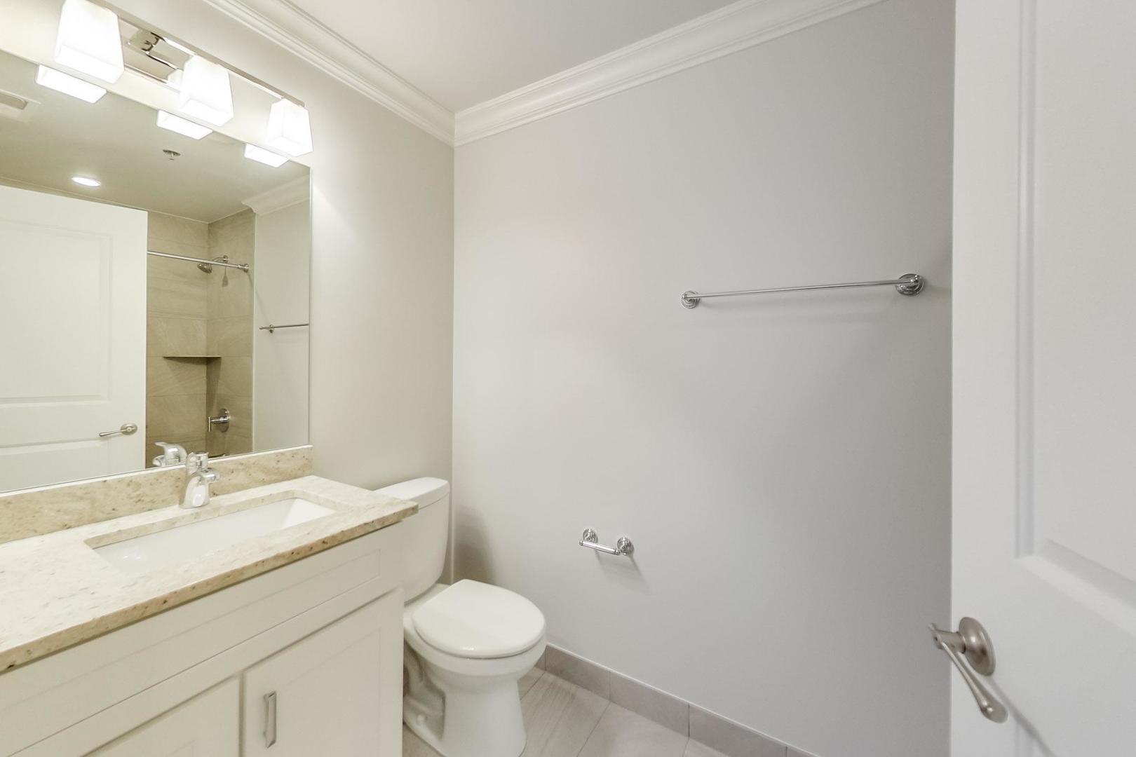 1249 West Madison Street, Unit 207 Chicago, IL 60607 - Photo 13 of 19 a bathroom with a sink a toilet and shower