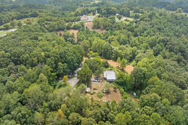 an aerial view of a houses with a lush green hillside