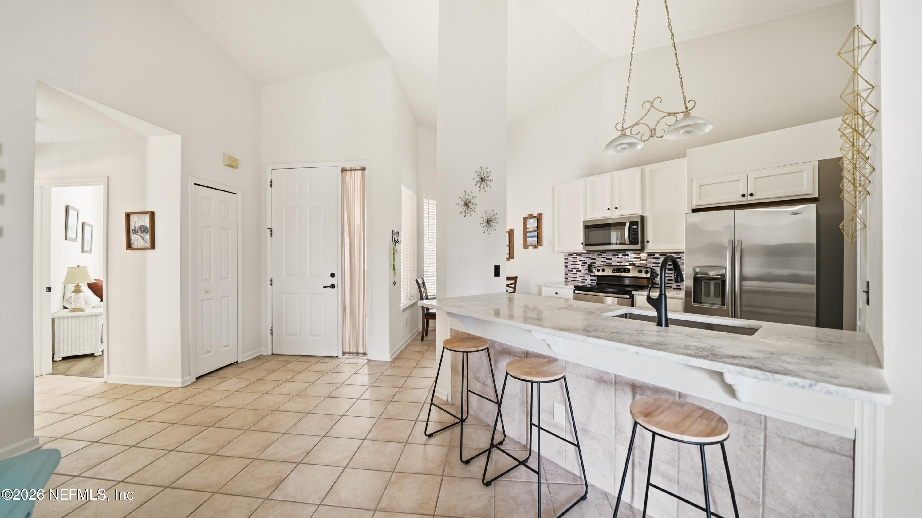 705 Augusta Circle St. Augustine, FL 32086 - Photo 11 of 53 a large kitchen with a refrigerator a sink a counter space and stainless steel appliances