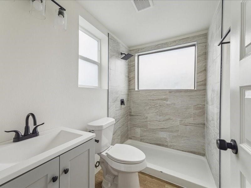 905 74th Street, Unit 3 Houston, TX 77011 - Photo 3 of 10 a bathroom with a sink toilet and a mirror