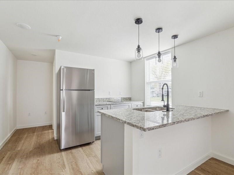 905 74th Street, Unit 3 Houston, TX 77011 - Photo 4 of 10 a kitchen with kitchen island a counter top space and refrigerator