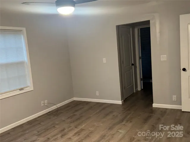 a view of a hallway with wooden floor and closet area