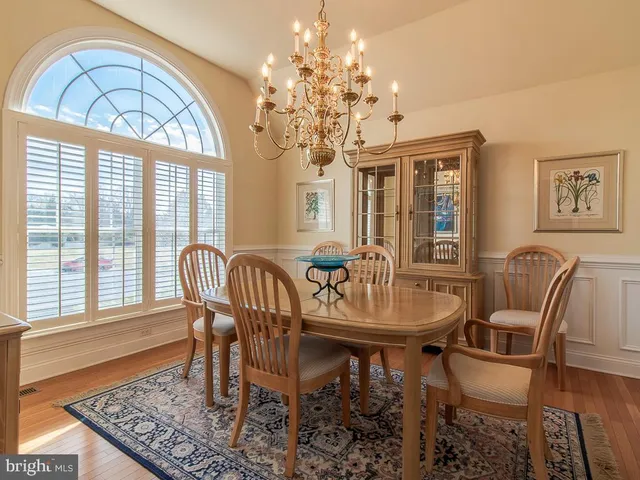 a view of a dining room with furniture a chandelier and wooden floor