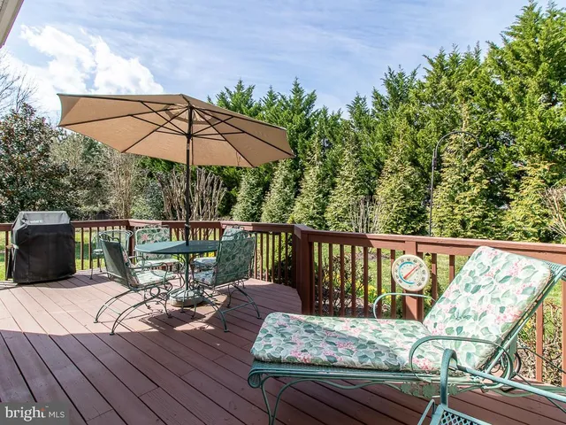 a view of a deck with wooden floor and barbeque oven