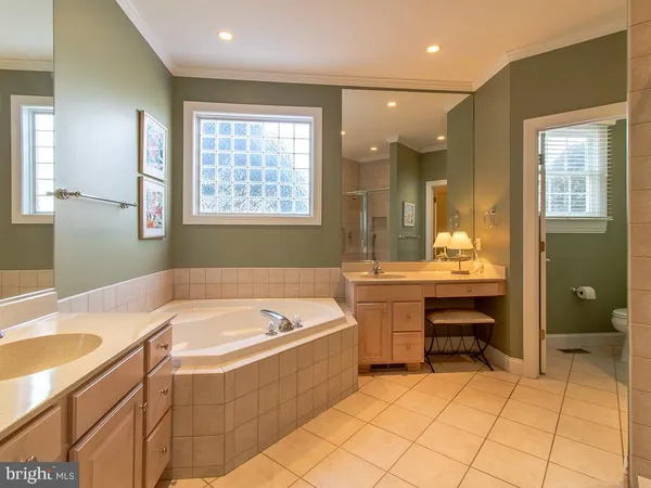 a bathroom with a tub sink and mirror