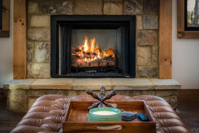 a living room with furniture a fireplace and a ceiling fan