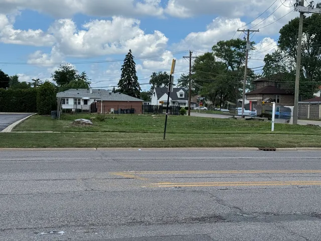 a front view of a house with a yard and trees