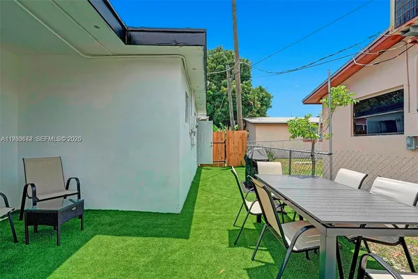 a backyard of a house with table and chairs