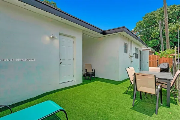 a backyard of a house with table and chairs