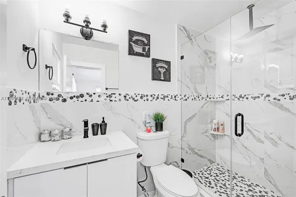 a bathroom with a sink a toilet and shower curtain