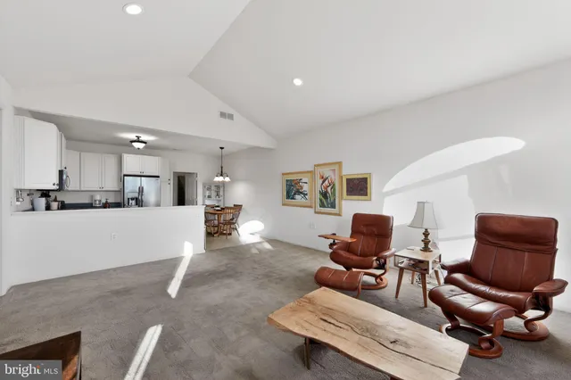 a living room with furniture and kitchen view