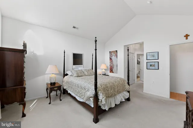 a spacious bedroom with a bed and a chandelier