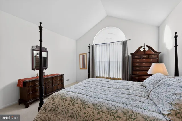 a bedroom with a bed and a flat tv screen on the dresser