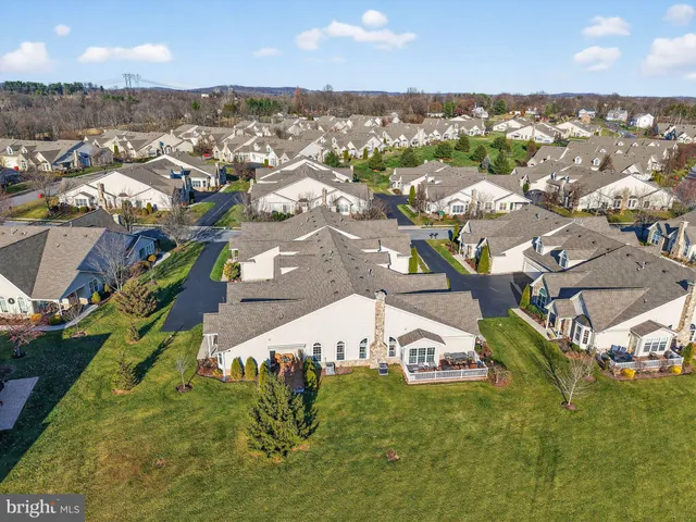 an aerial view of residential houses with outdoor space and trees