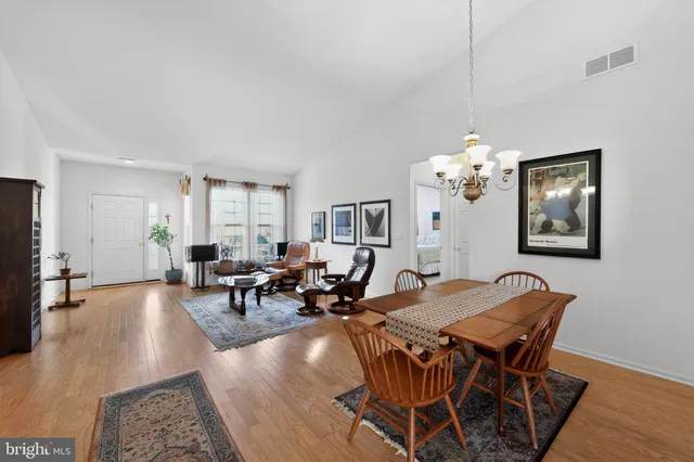 a living room with furniture a dining table and a chandelier