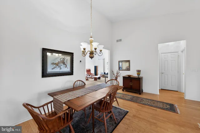 a view of a dining room with furniture a chandelier and wooden floor