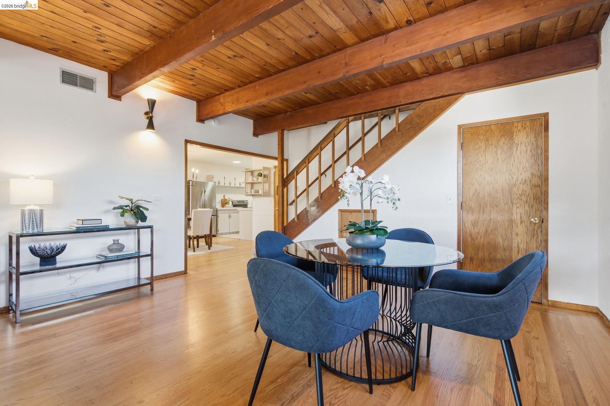 4522 Santa Rita Road El Sobrante, CA 94803 - Photo 31 of 58 Exposed wood beam ceiling, wood-finish flooring, wood staircase, white wall finishes, and a framed doorway