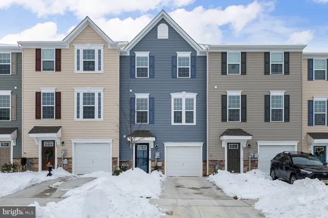 a view of a white house with large windows and a yard