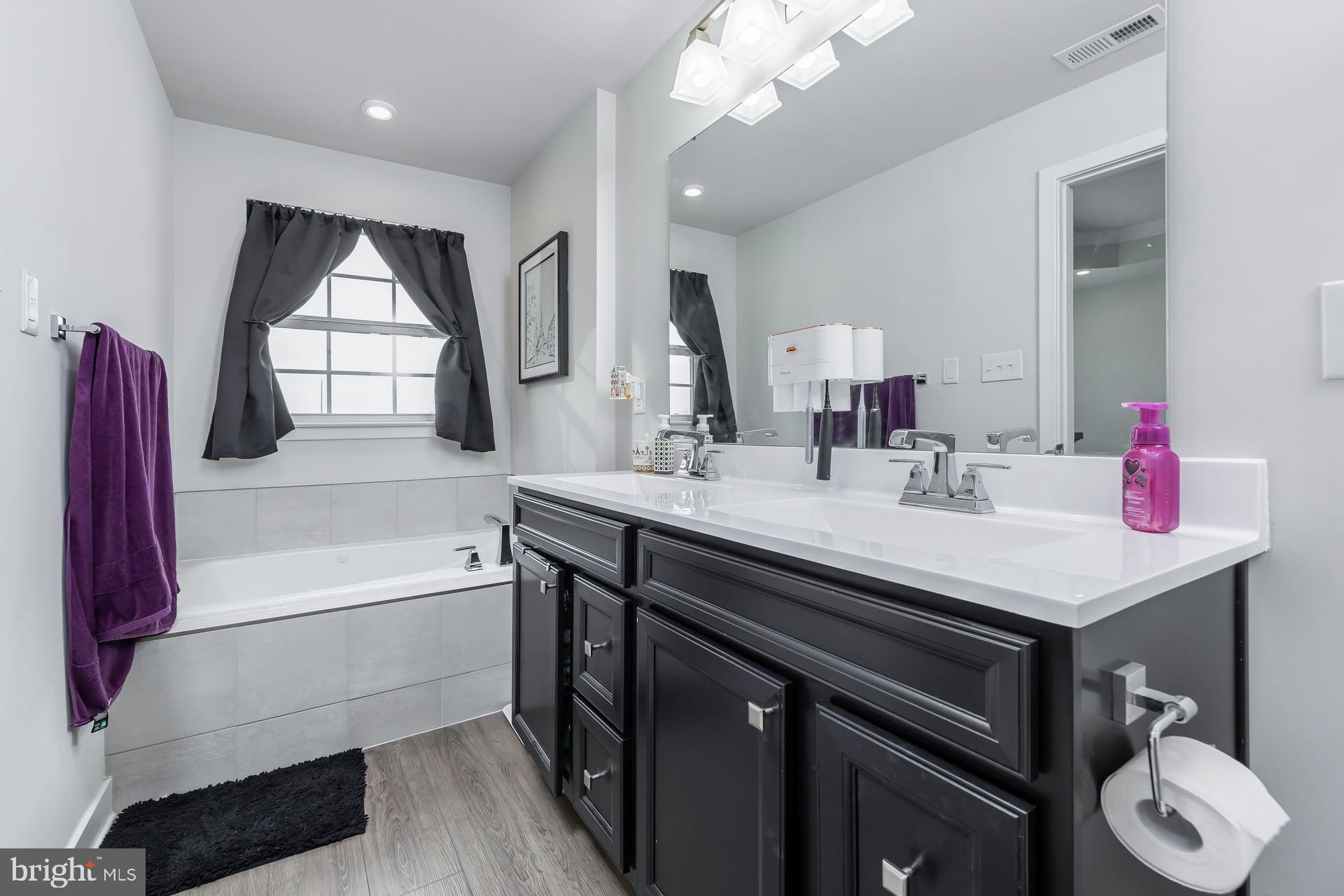 246 Freedom Way Sicklerville, NJ 08081 - Photo 16 of 23 a bathroom with a sink vanity tub and a mirror