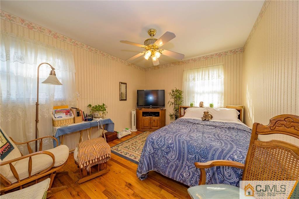 857 Hermann Road North Brunswick, NJ 08902 - Photo 16 of 25 a living room with a bed and a flat screen tv